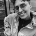 a person with glasses and short hair looks at the camera