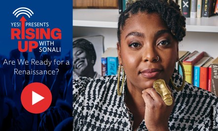 Evette Dionne, a Black woman with locs and a large gold ring on her middle finger, looks at the camera.